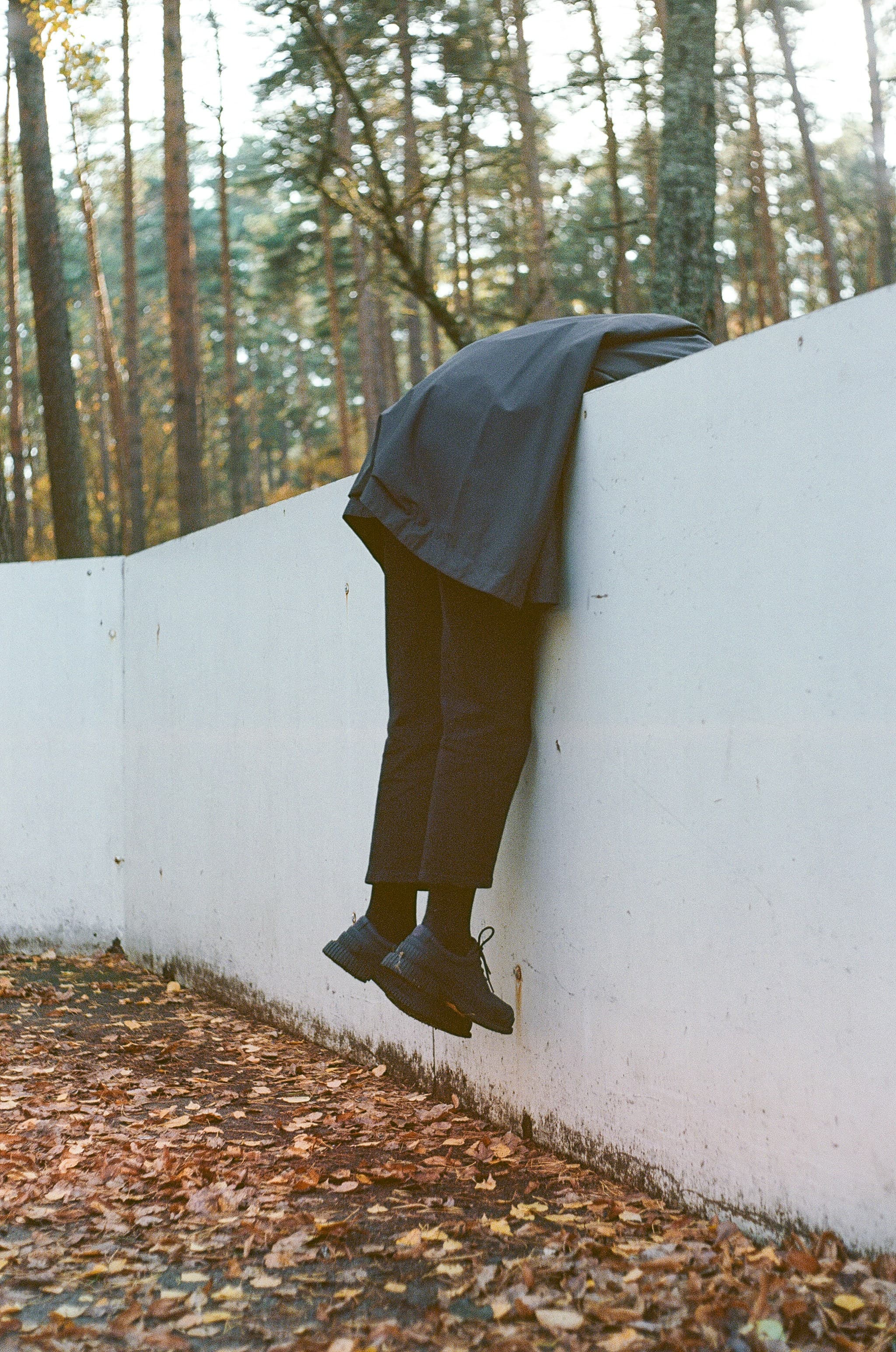 Person leaning on a white concrete fence